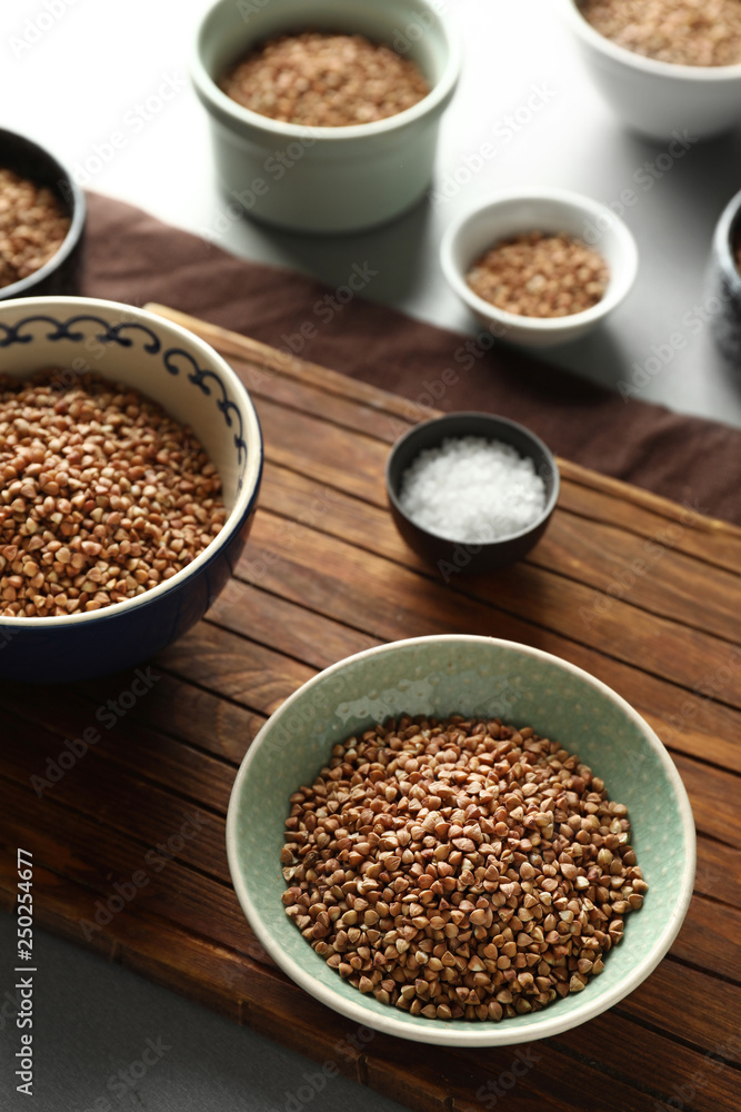 Bowls with raw buckwheat on table