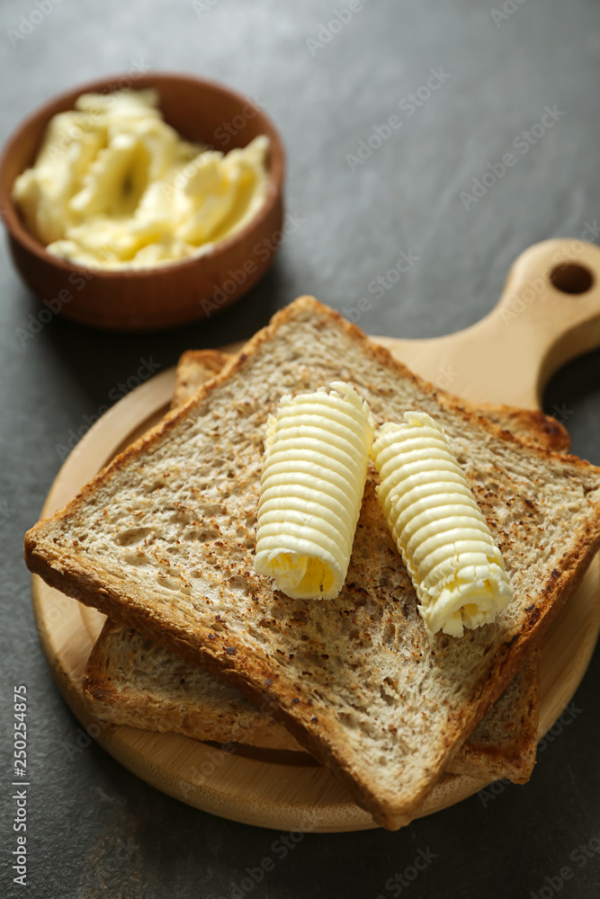 Tasty toasts with butter curls on table