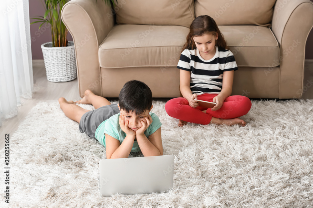 Cute little children watching cartoons at home