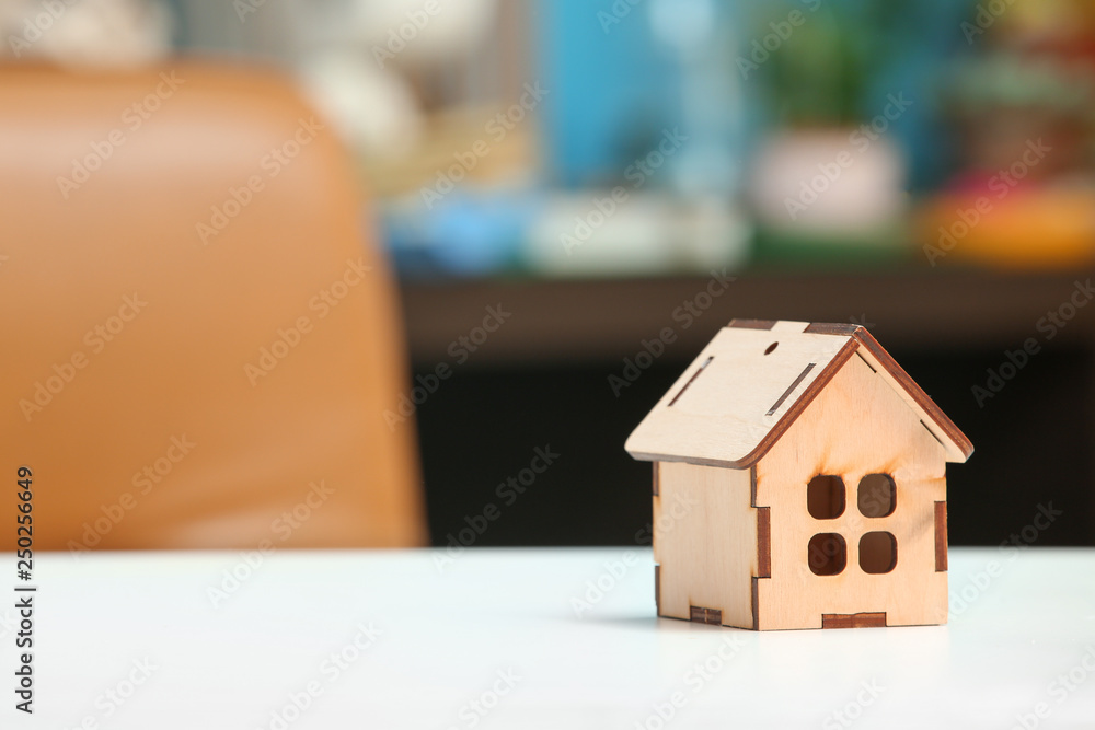 Figure of house on white table. Property insurance concept