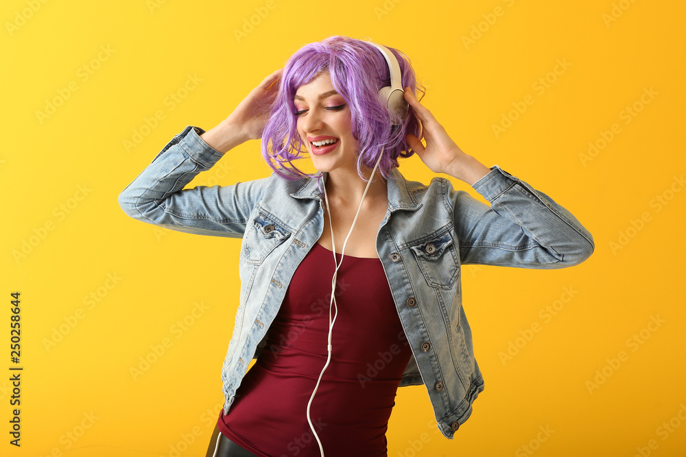 Beautiful young woman listening to music on color background