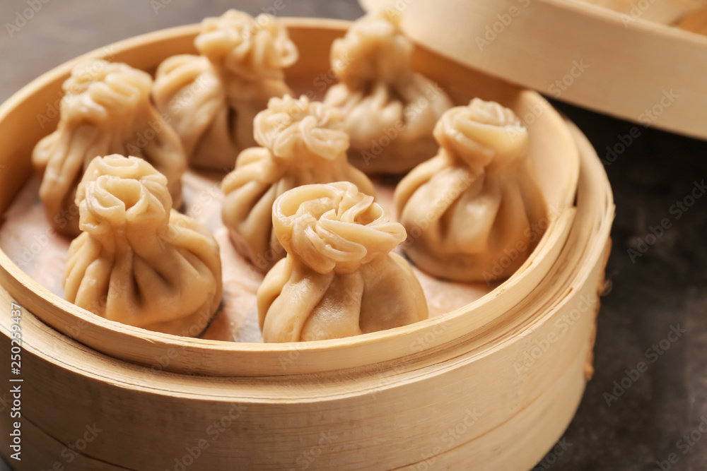 Bamboo steamer with tasty dumplings on table, closeup