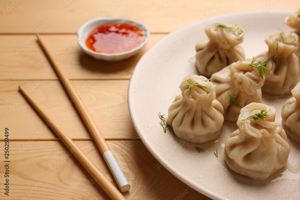 Plate with tasty dumplings on wooden table