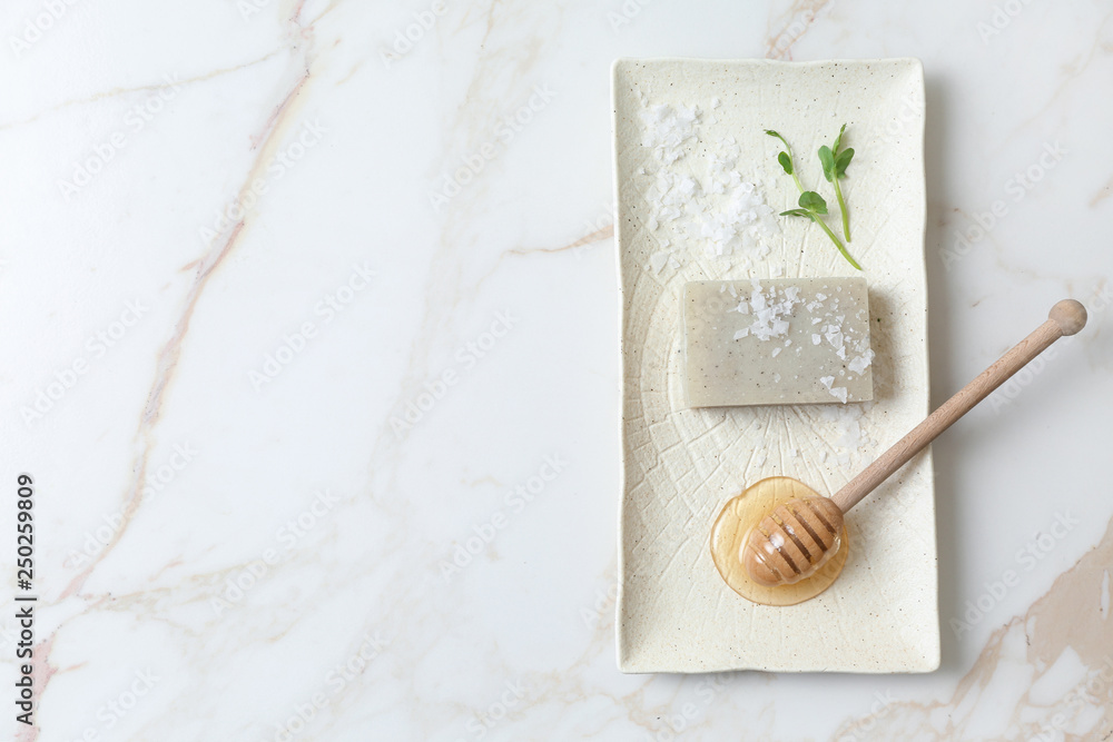 Natural soap, sea salt and honey for skin care on light background