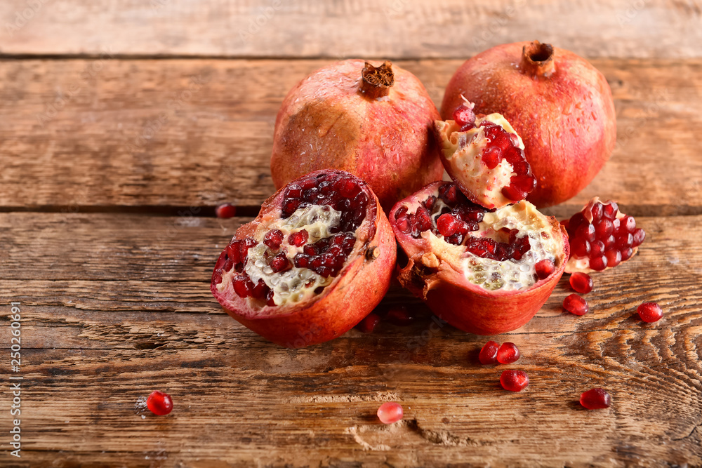 Delicious pomegranates on wooden table