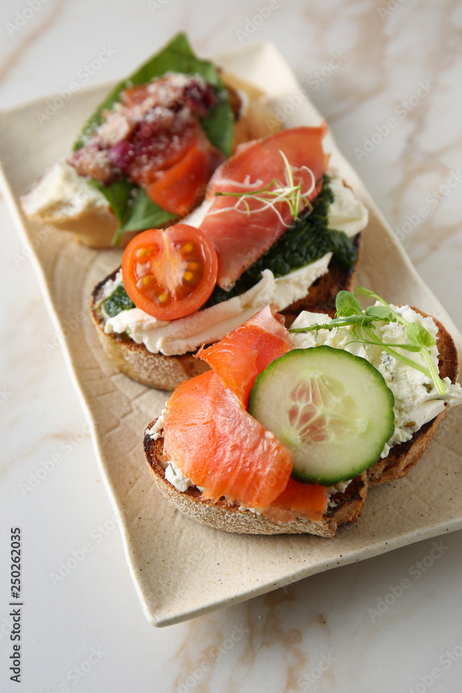 Plate with fresh tasty bruschettas on light background