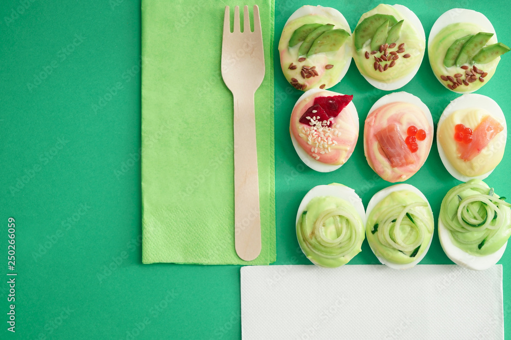 Composition with tasty deviled eggs on color background