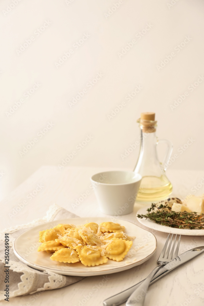 Plate with tasty ravioli on table