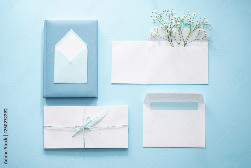 Paper envelopes with flowers on color background