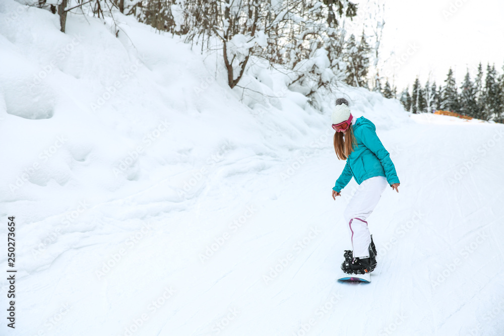 Sporty female snowboarder at winter resort