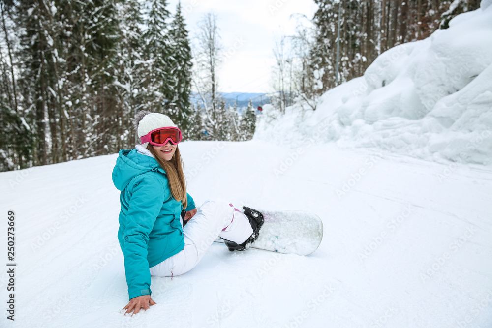 Sporty female snowboarder at winter resort