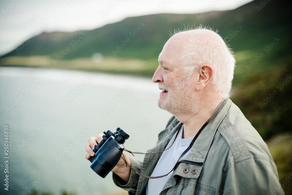 Happy senior man with a pair of binoculars