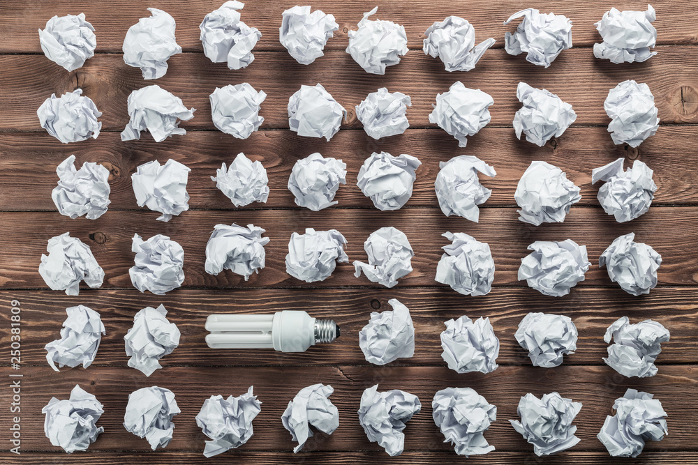 Ideological concept with wastepaper light bulb on wooden table