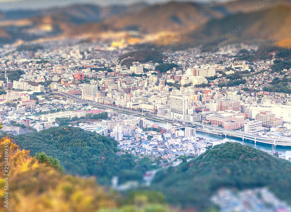 Business concept, tilt shift effect modern cityscape of nagasaki dusk from mount inasa, the new top 