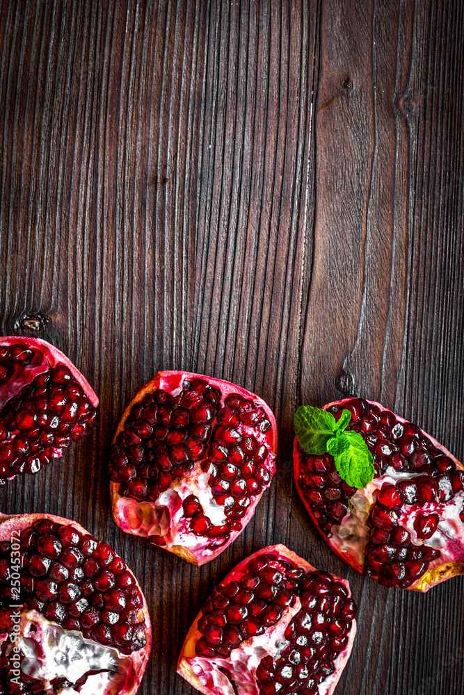 sliced pomegranate on wooden background top view