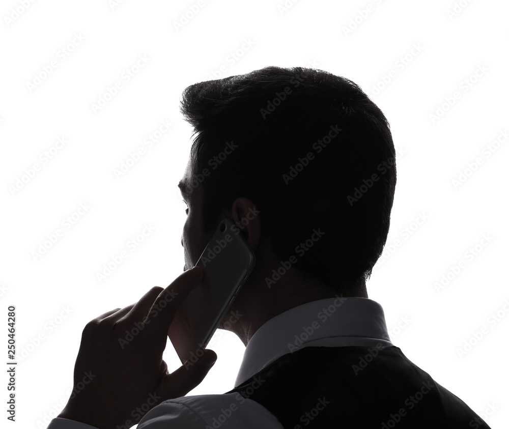 Handsome young businessman talking by mobile phone against white background