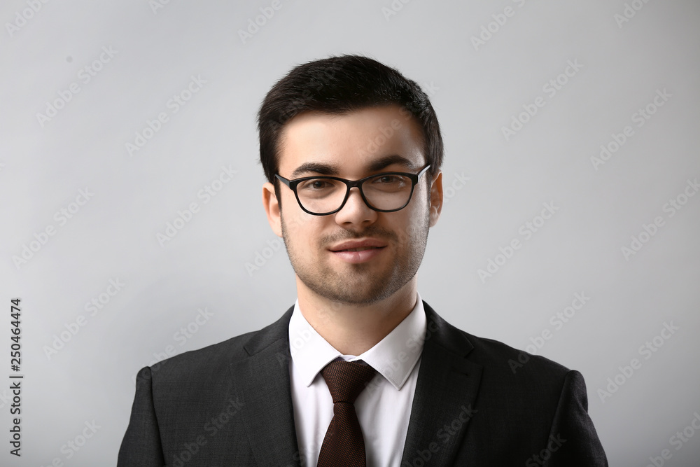 Portrait of handsome young businessman on light background