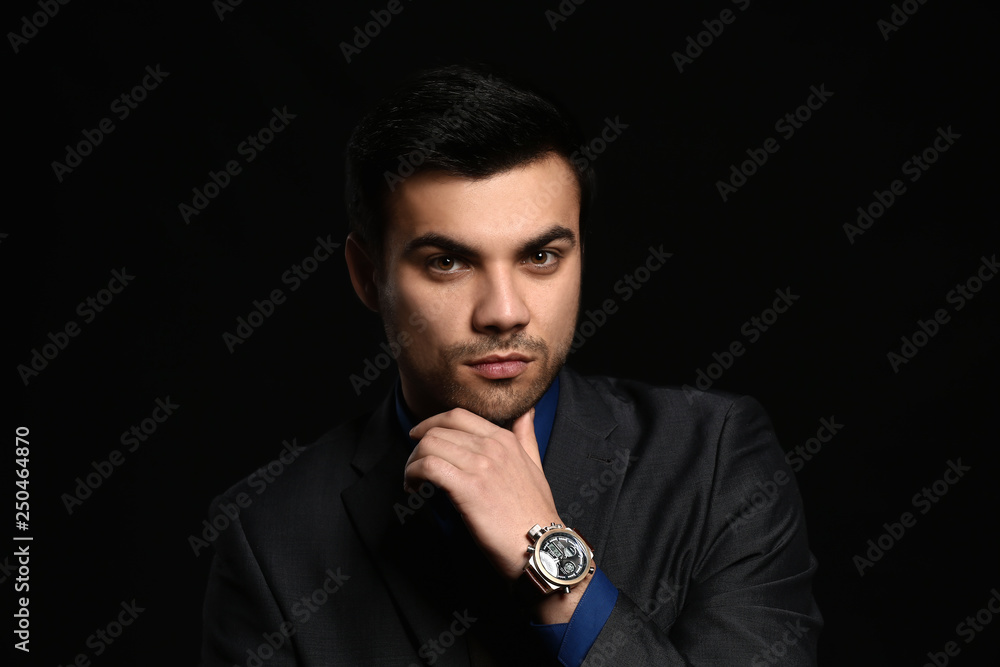 Portrait of handsome young businessman on dark background