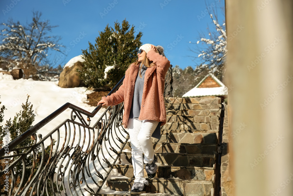 Beautiful woman on stairs at snowy resort