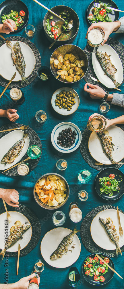 鱼、薯条、啤酒聚会、朋友们的饮食。人手平放，啤酒杯