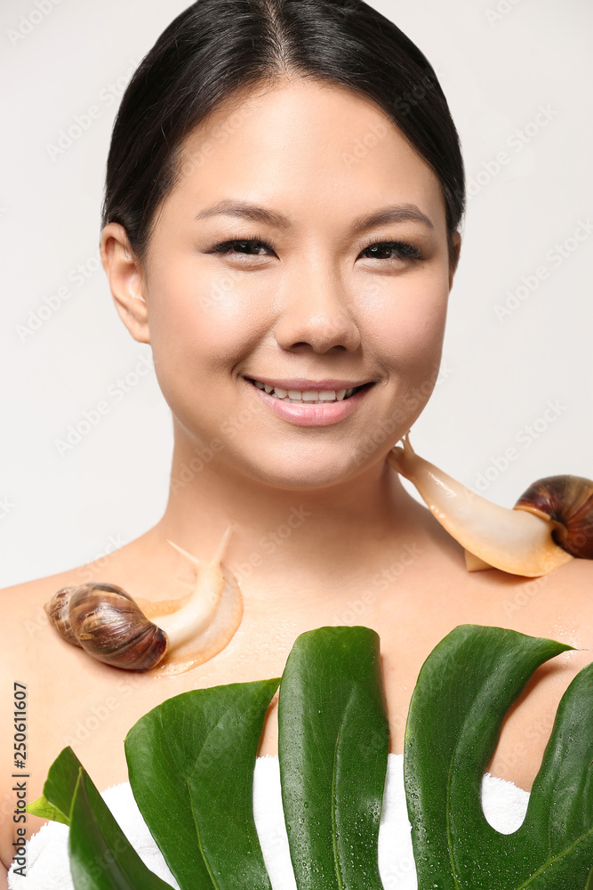 Asian woman with giant Achatina snails on white background