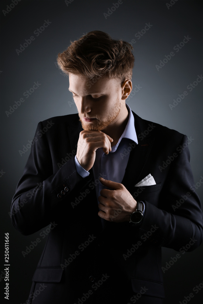 Handsome fashionable businessman on grey background