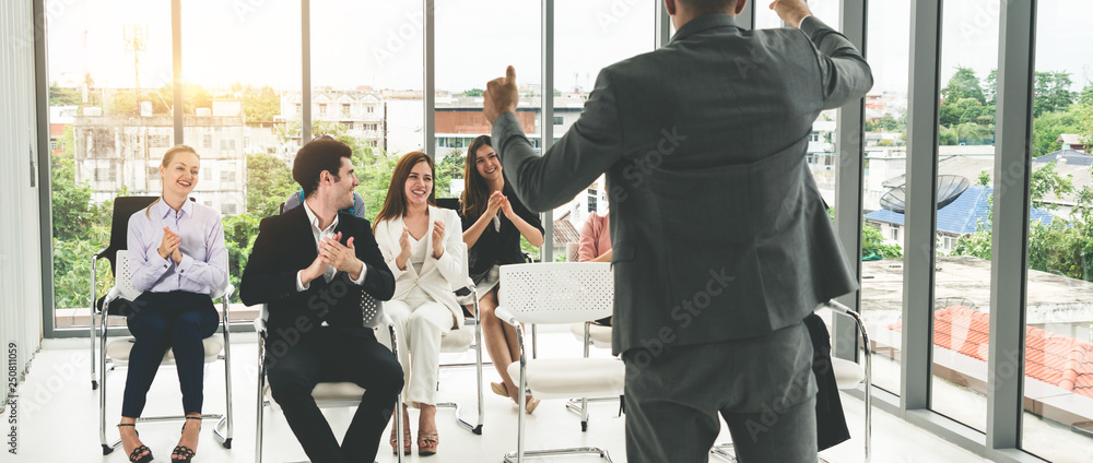 Businesswomen and businessmen in group meeting.