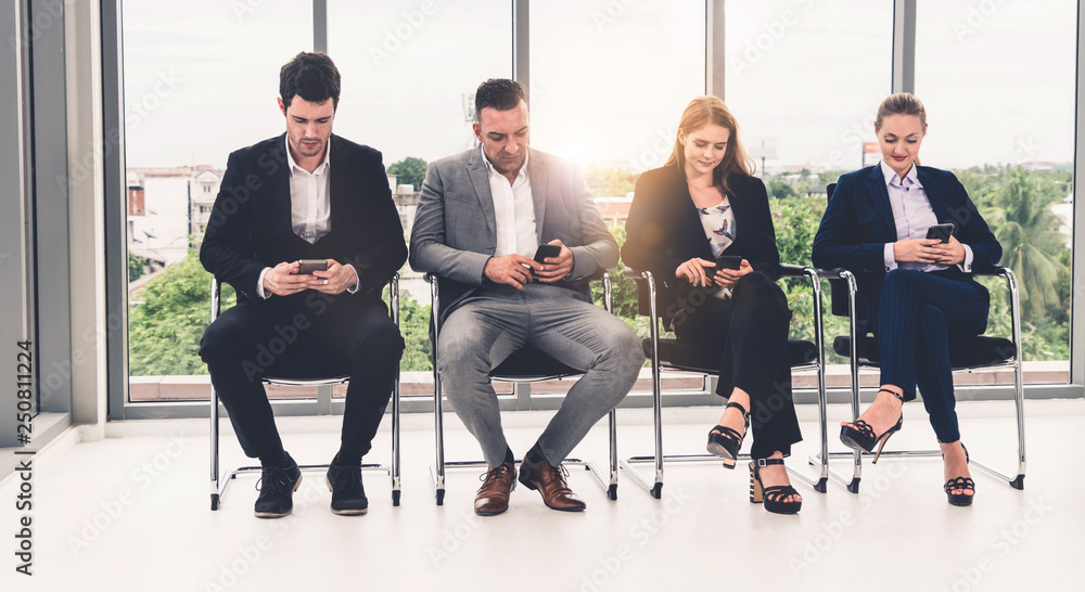 Businesswomen and businessmen using mobile phone.