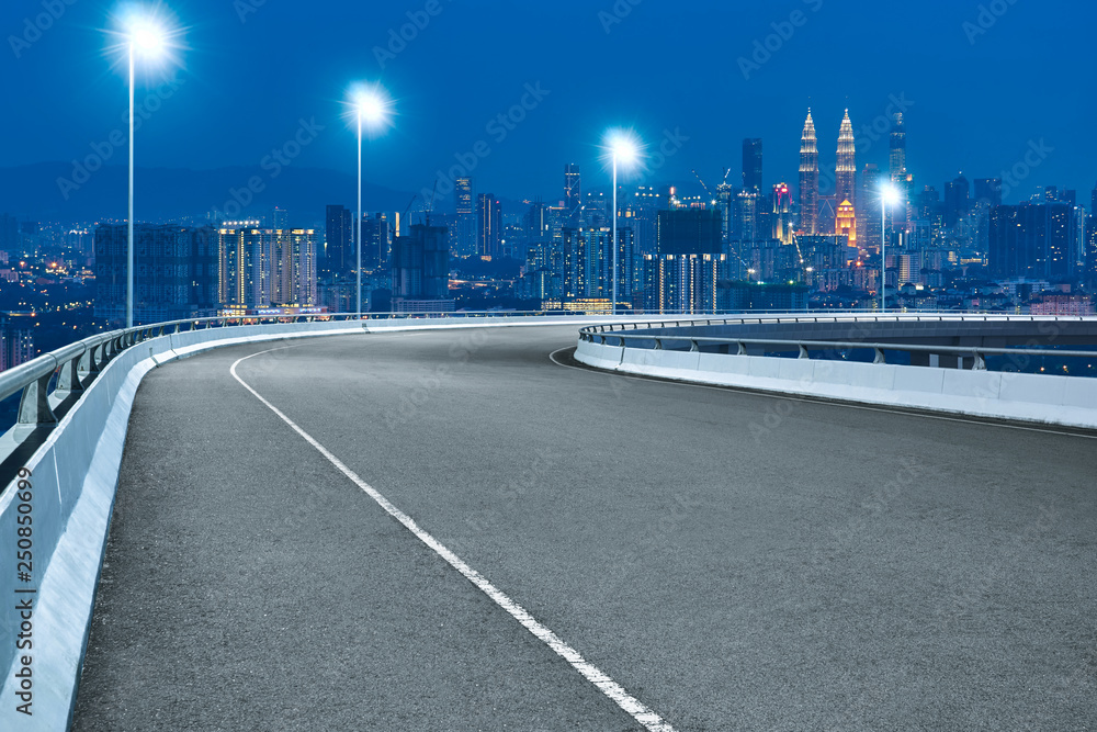 高速转角立交桥沥青路，吉隆坡城市景观，夜景。