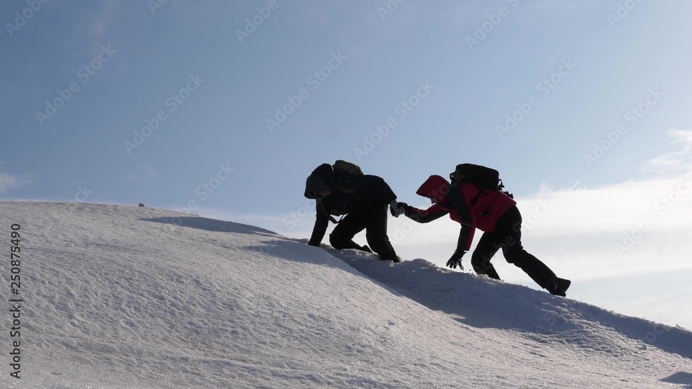 登山者携手登上雪山之巅。冬季的旅行者团队朝着他们的目标前进