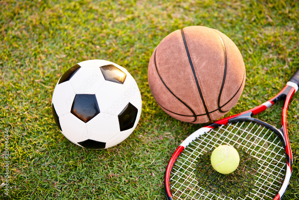 football basketball and tennis ball and racket on grass