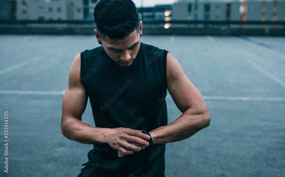 Muscular man monitoring his progress on smartwatch