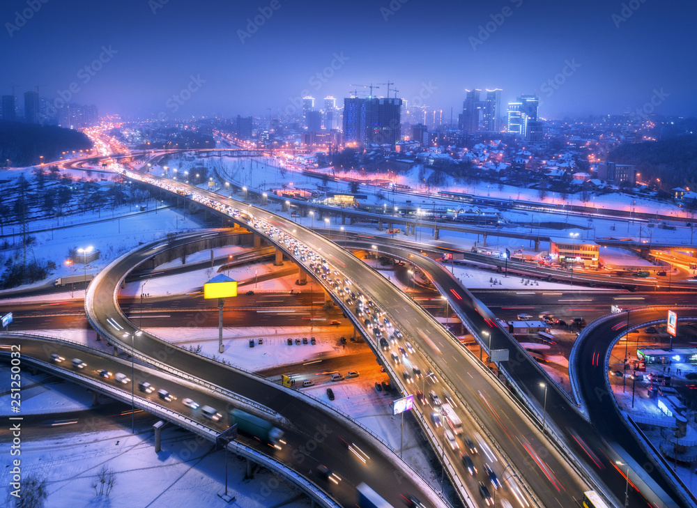 雾中现代城市夜间道路鸟瞰图。高速公路交通俯视图。冬季城市