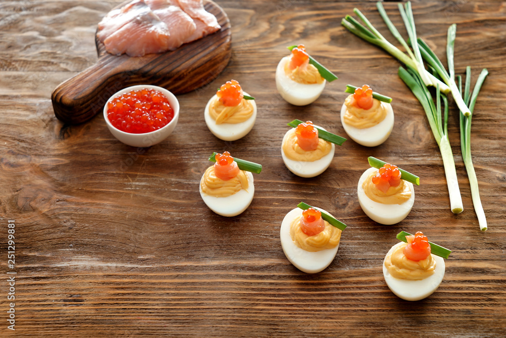 Tasty deviled eggs on wooden table