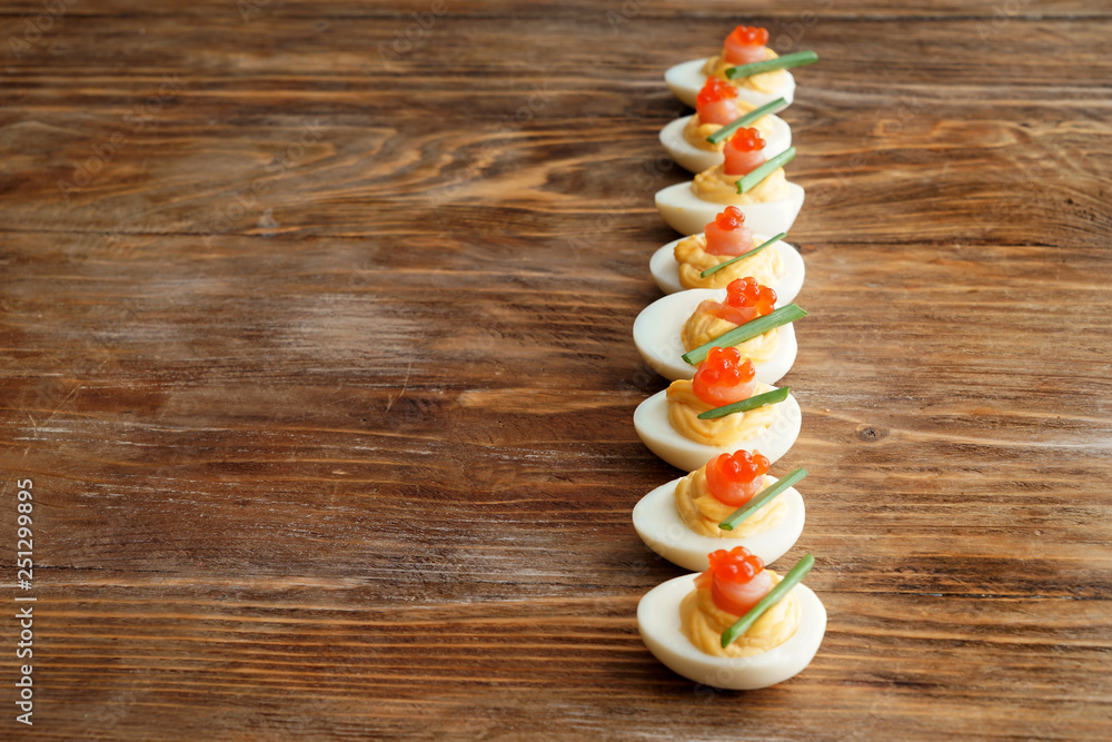 Tasty deviled eggs on wooden table