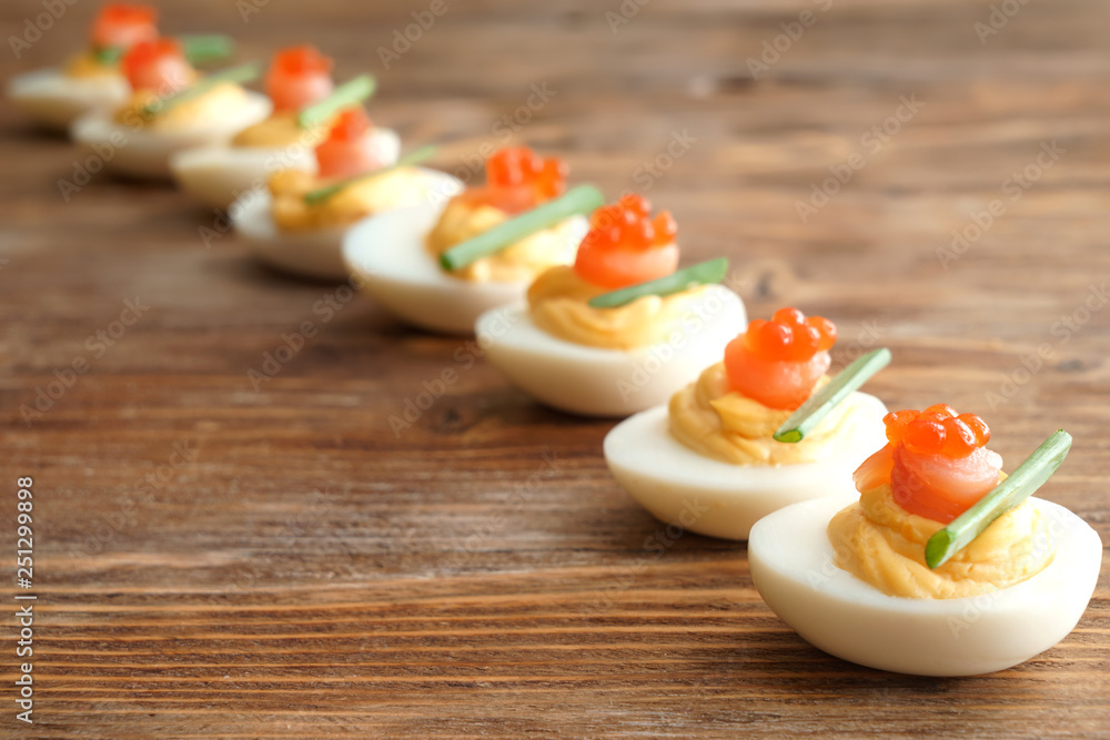 Tasty deviled eggs on wooden table