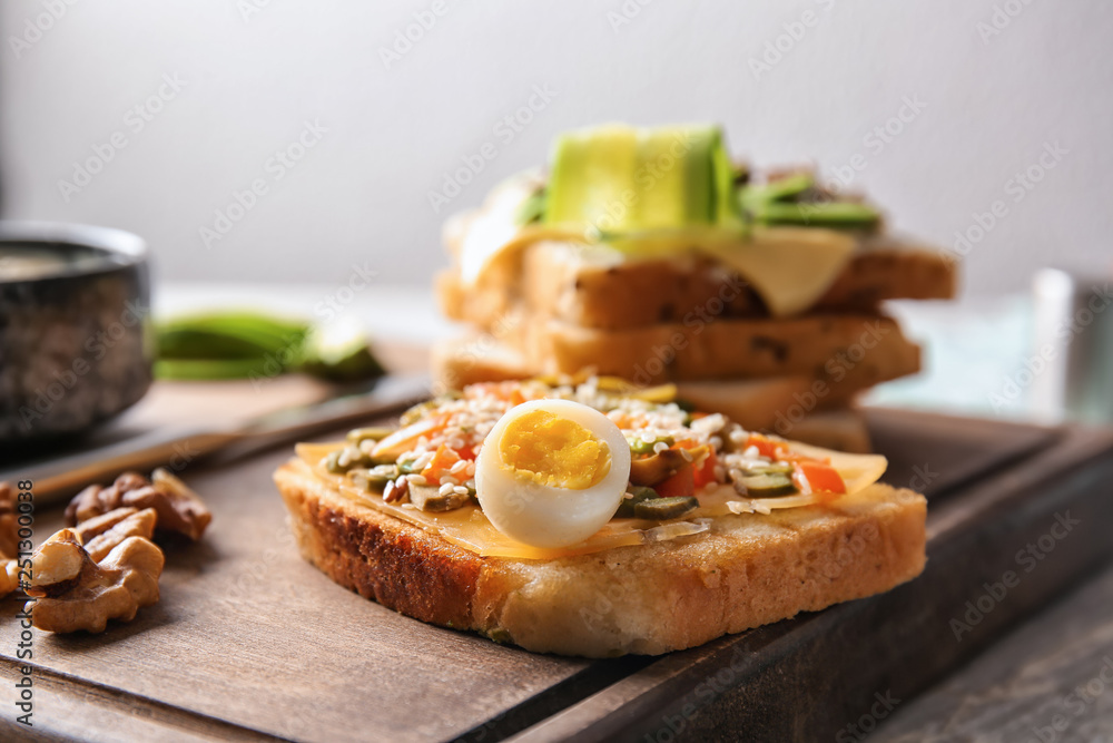 Tasty avocado sandwich on wooden board