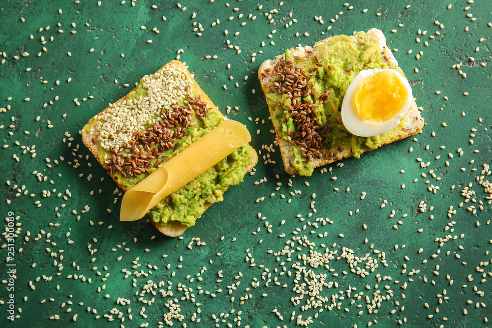 Tasty avocado sandwiches on color background