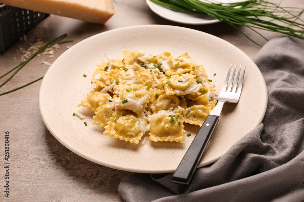 Plate with tasty ravioli on table