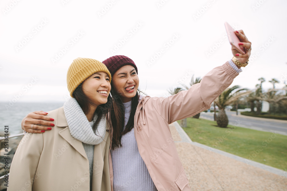 快乐的女孩朋友站在户外自拍