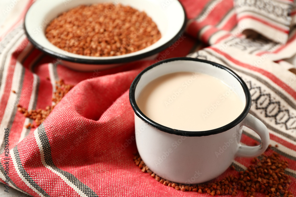 Mug of tasty buckwheat milk on table