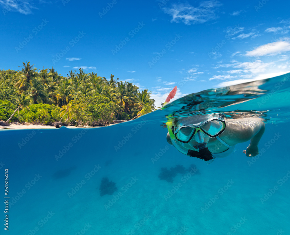 Under and above water view of woman snorkeling