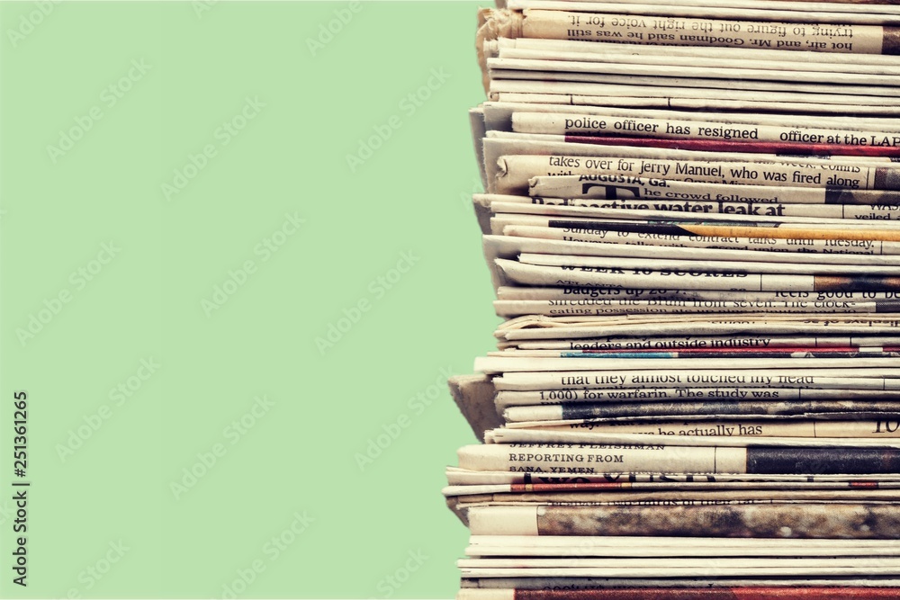 Pile of printed newspapers on blue background