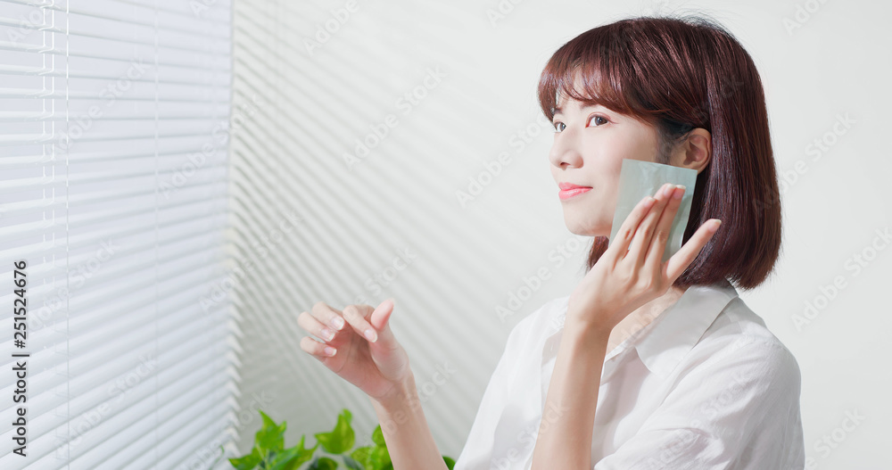 woman use oil blotting paper