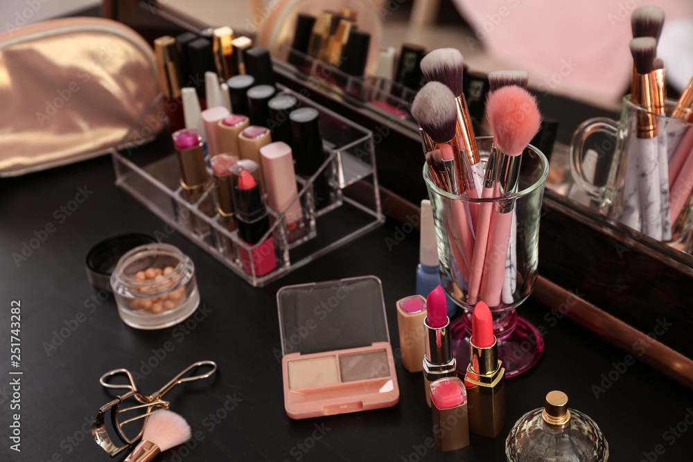 Set of makeup brushes and cosmetics on table