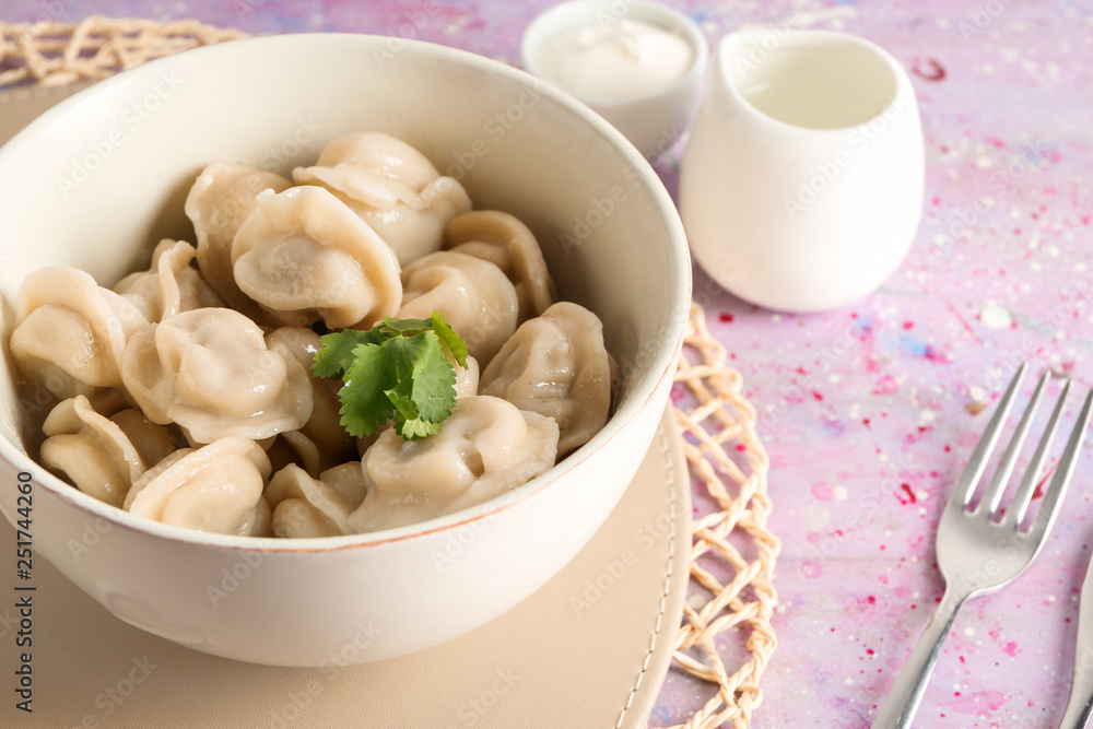 Bowl with tasty dumplings on table, closeup