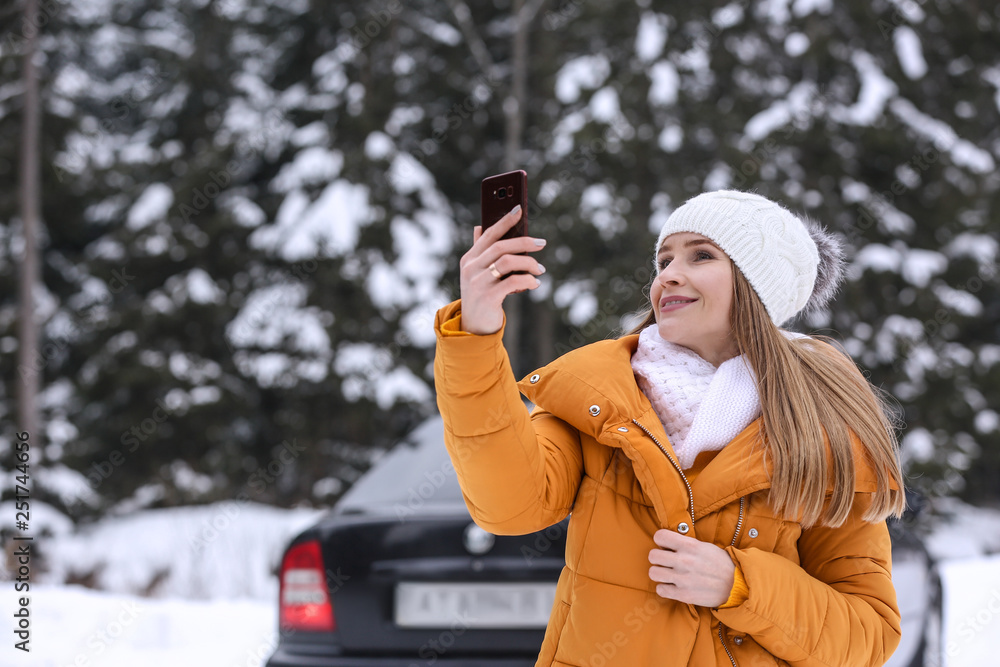 Young woman taking selfie at snowy winter resort