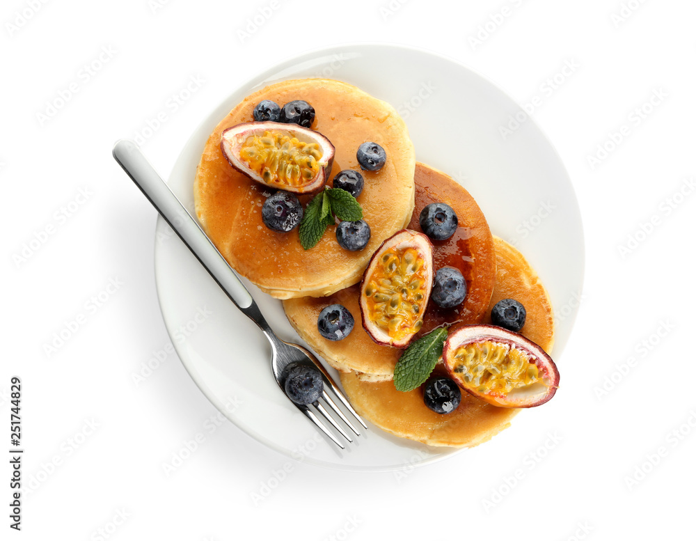 Tasty pancakes with passion fruit and berries on white background