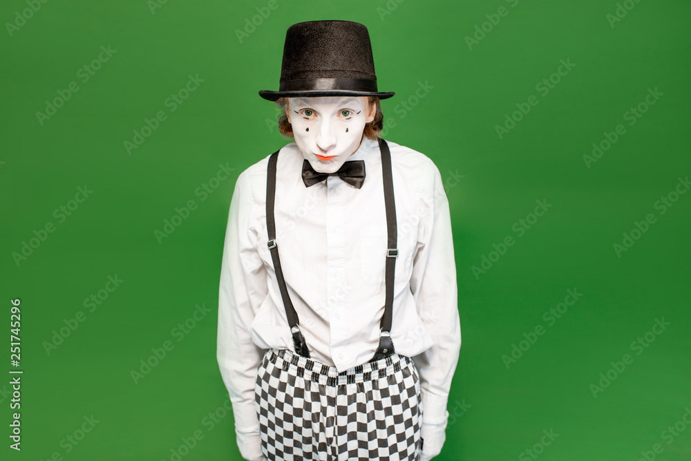 Portrait of an actor as a pantomime with white facial makeup posing with expressive emotions isolate