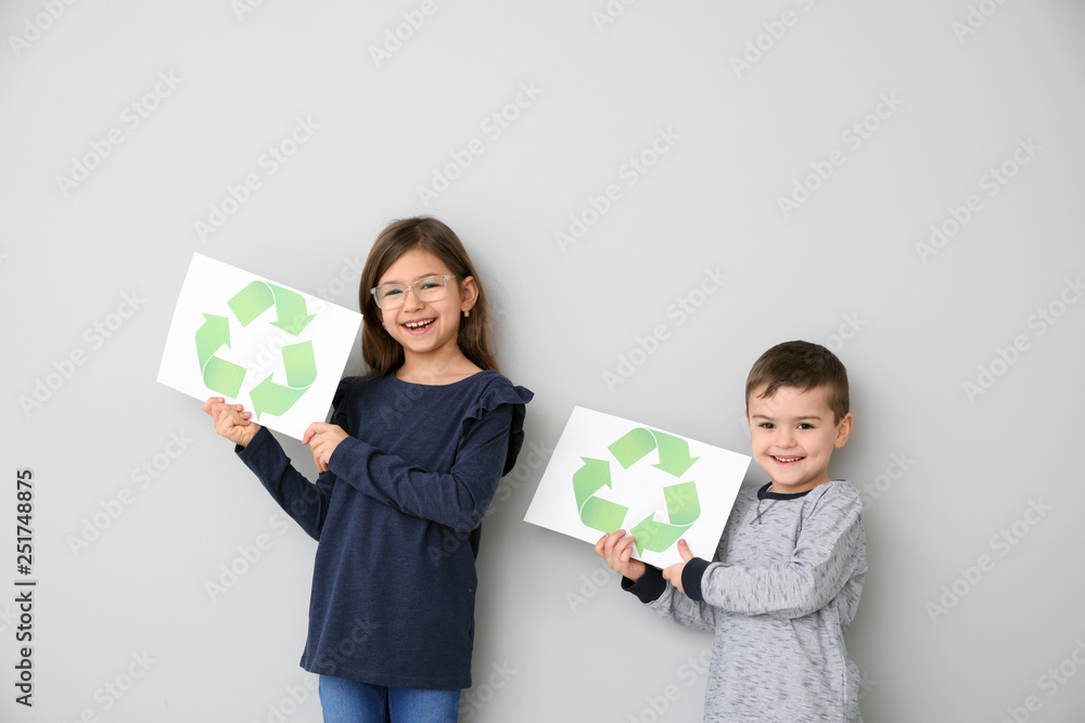 Children holding paper sheets with recycling symbol on white background